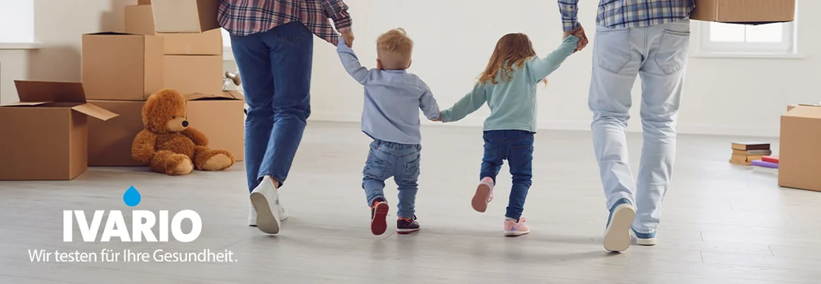 Familie geht durch Wohnung mit Umzugskartons